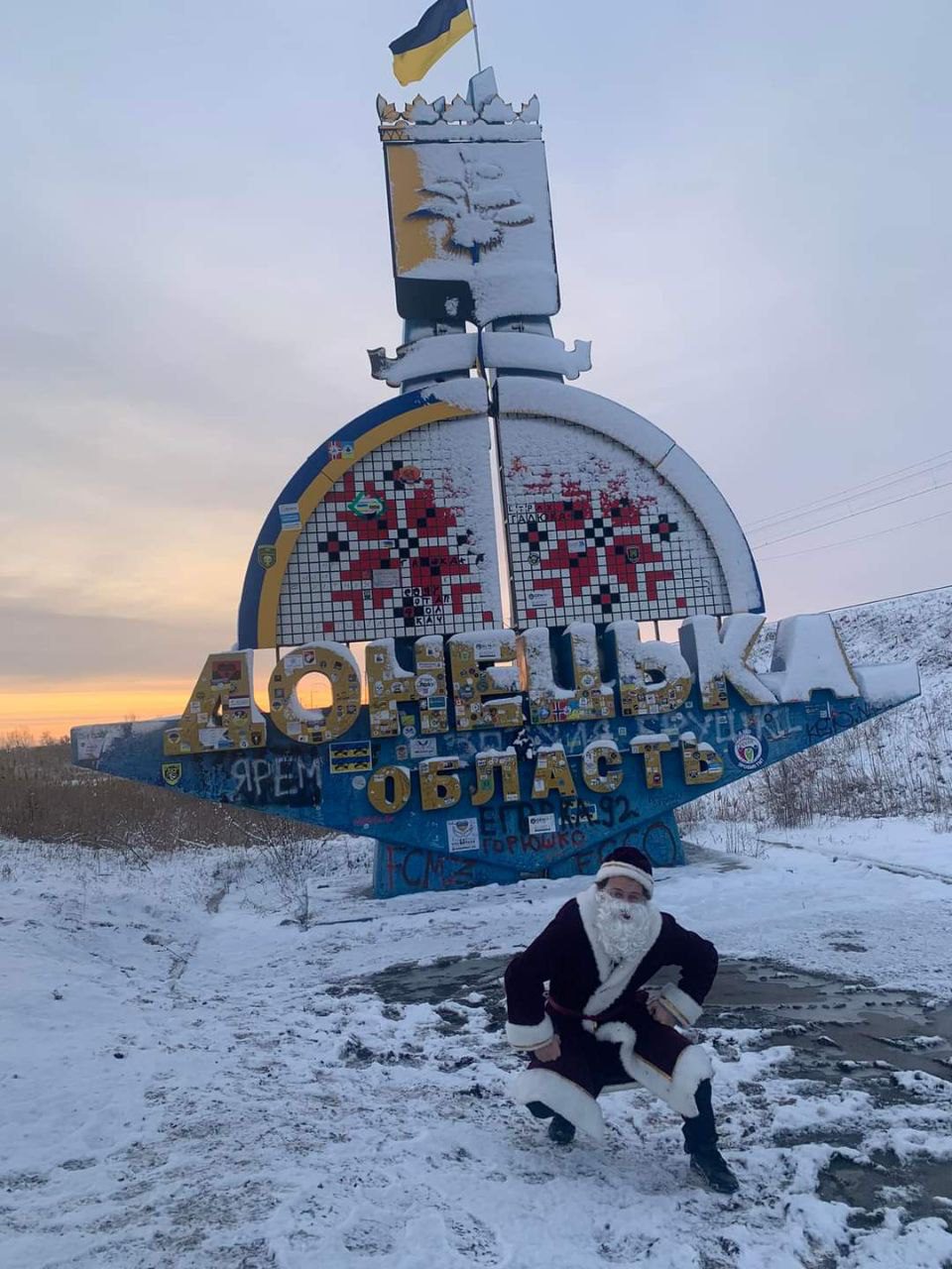 Волонтер Олексій в костюмі Санти біля в'їзду в Донецьку область