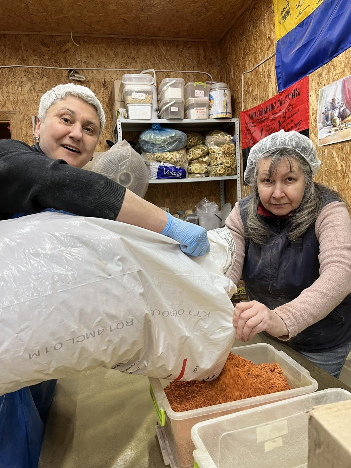 Волонтерки насипають у контейнери їжу в хабі «Борщ для ЗСУ»