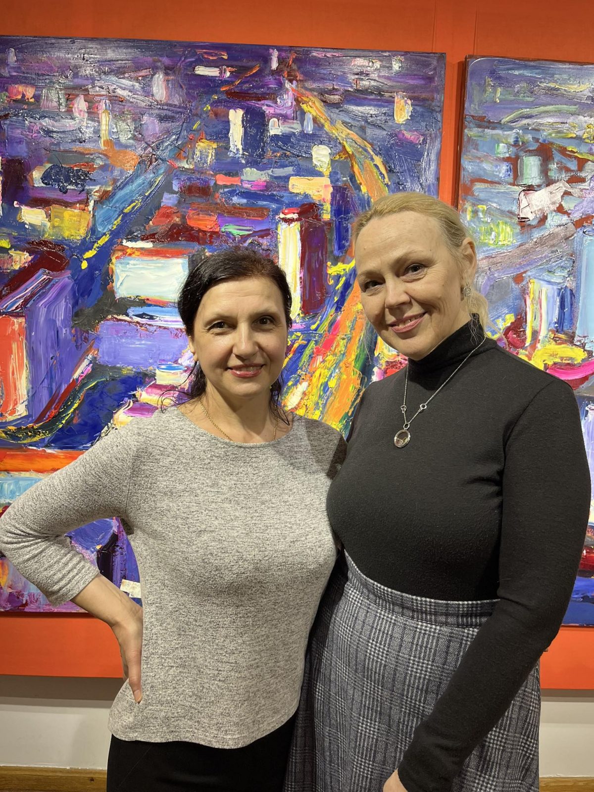 Дві жінки на фоні картини у Музеї української діаспори