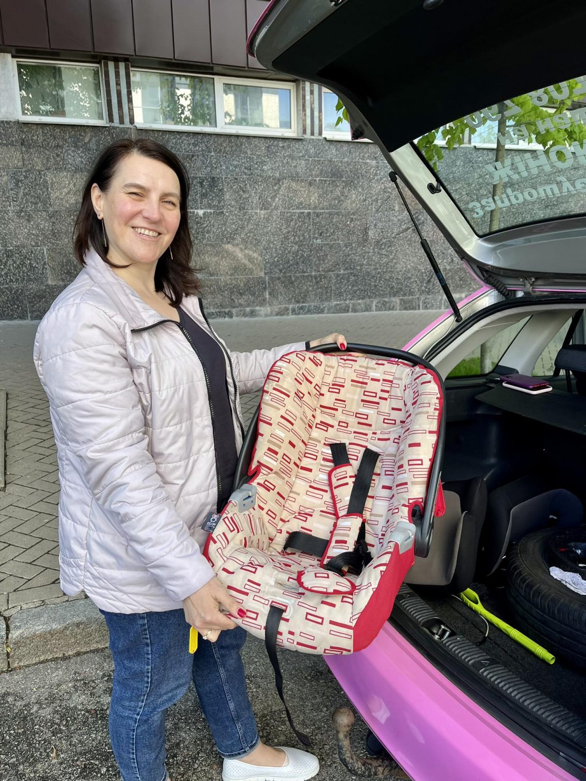 Водійка Олена біля машина Pink Taxi з автолюлькою