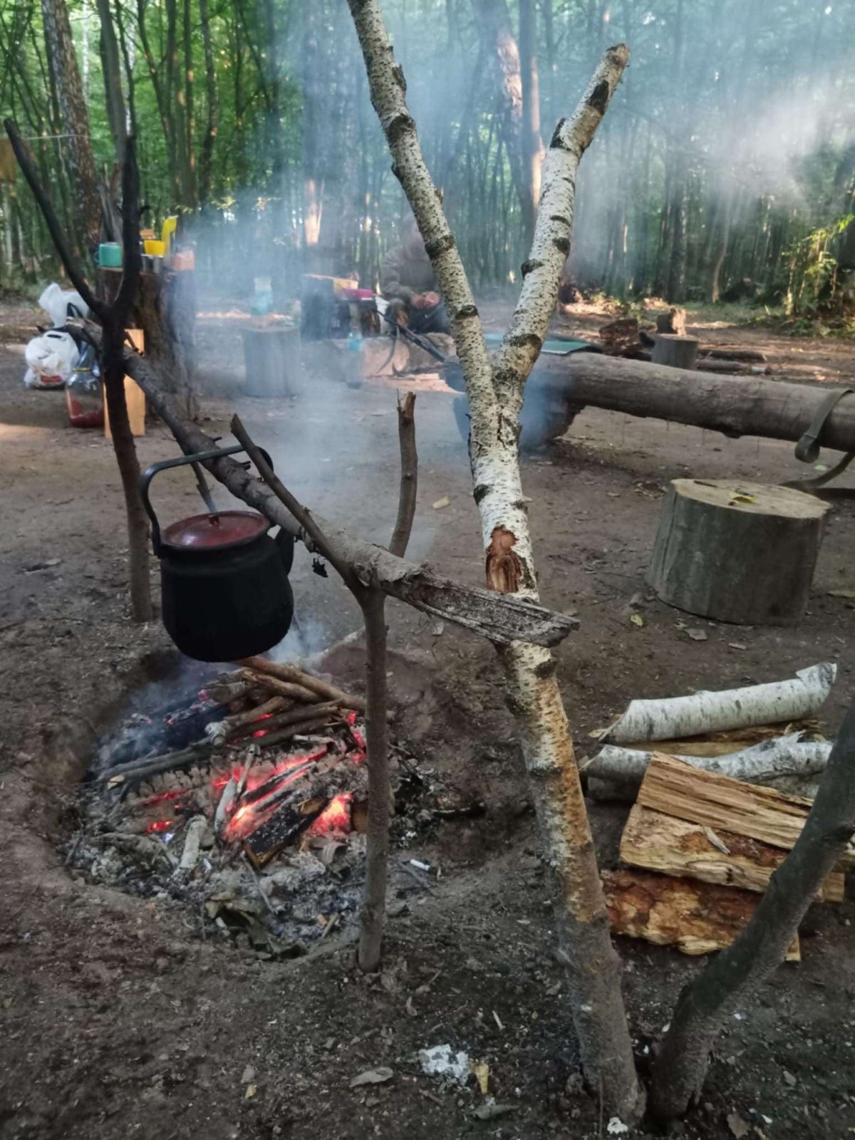 Чайник над багаттям у лісі