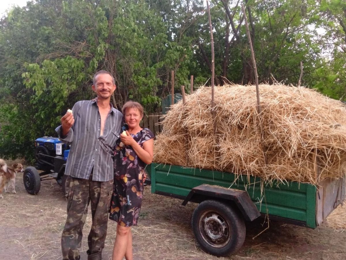 Жінка з чоловіком у селі біля копни сіна